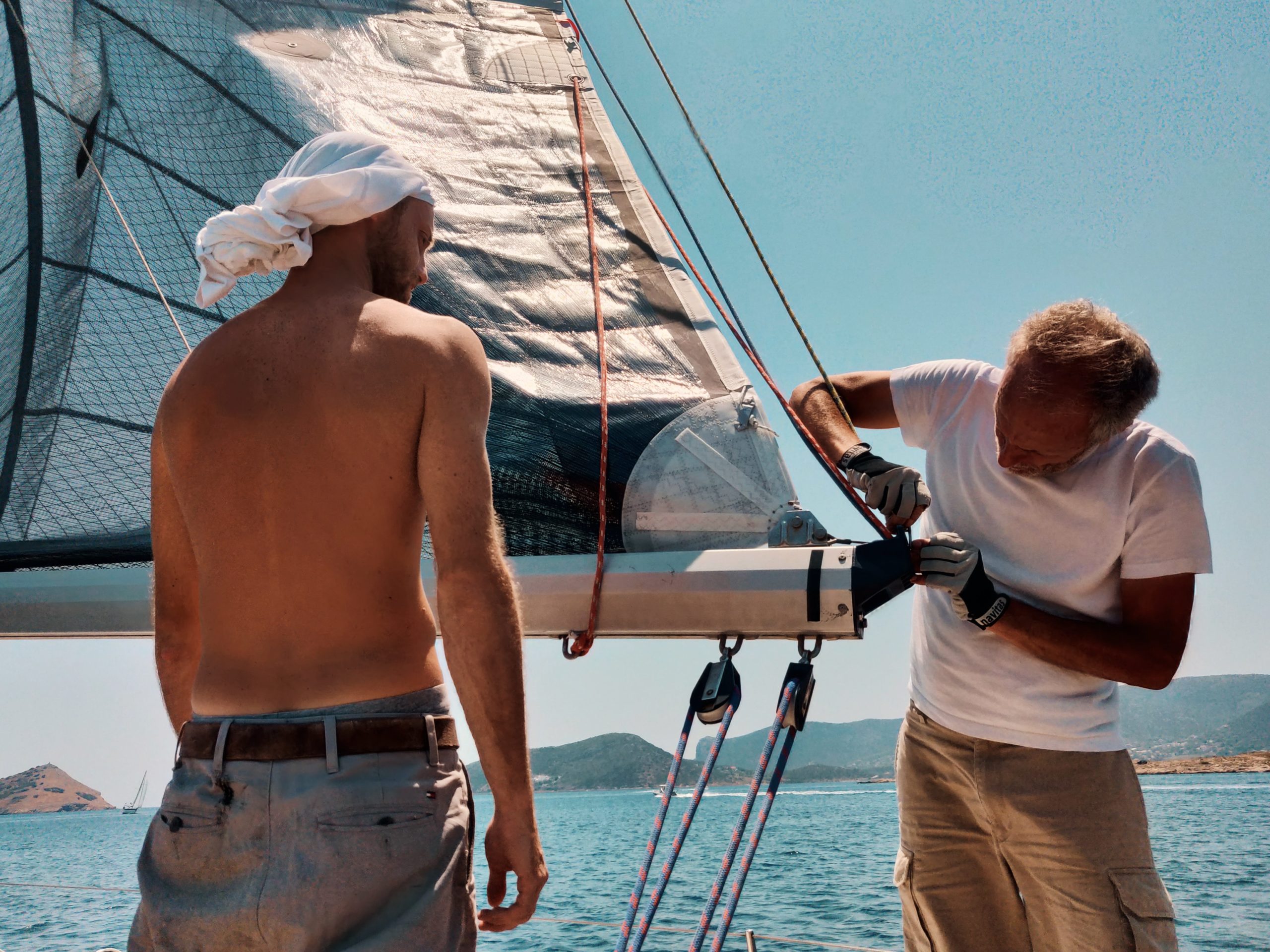 Sailor teaching to fix a yacht detail